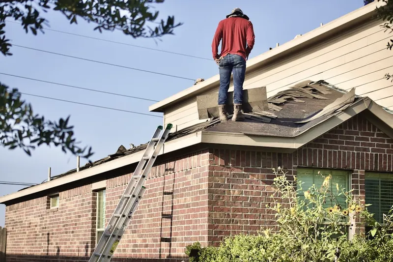 Professional roofer working on a residential roof in New Weston
